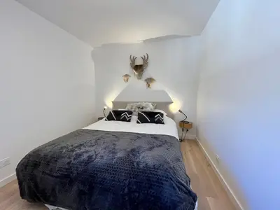 a bedroom with a large bed with a black blanket at Duplex élégant au centre, vue vallée, confort moderne - FR-1-624-185 in Samoëns