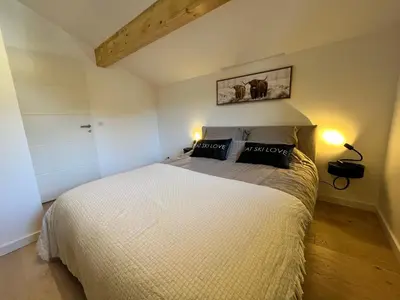 a bedroom with a large white bed in a room at Duplex élégant au centre, vue vallée, confort moderne - FR-1-624-185 in Samoëns