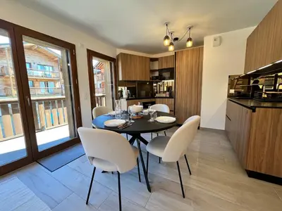a dining room with a black table and white chairs at Duplex élégant au centre, vue vallée, confort moderne - FR-1-624-185 in Samoëns