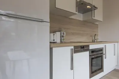 a kitchen with white cabinets and stainless steel appliances at Résidence Les Periades - Chamonix in Chamonix-Mont-Blanc