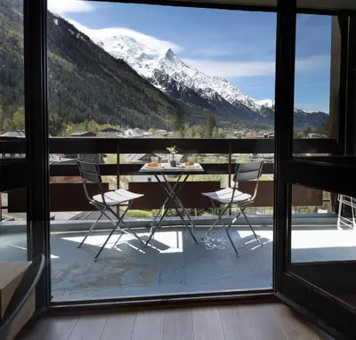 a table and chairs on a balcony with a mountain view at Résidence Les Periades - Chamonix in Chamonix-Mont-Blanc