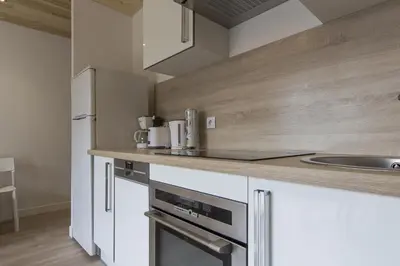 a kitchen with white cabinets and stainless steel appliances at Résidence Les Periades - Chamonix in Chamonix-Mont-Blanc