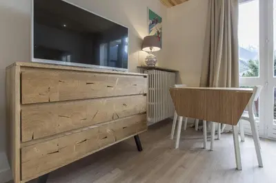 a bedroom with a dresser with a television on top at Résidence Les Periades - Chamonix in Chamonix-Mont-Blanc