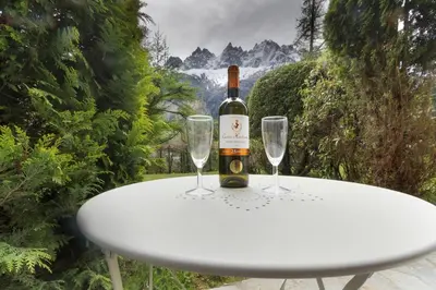 a bottle of wine sitting on a table with two wine glasses at Résidence du Brévent - Chamonix Village in Chamonix-Mont-Blanc