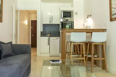 a living room with a couch and a table in a kitchen at Résidence du Brévent - Chamonix Village in Chamonix-Mont-Blanc