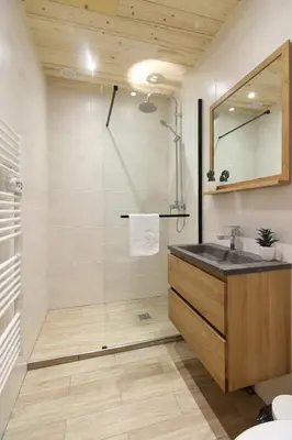 a bathroom with a shower with a sink and a mirror at Résidence du Brévent - Chamonix Village in Chamonix-Mont-Blanc