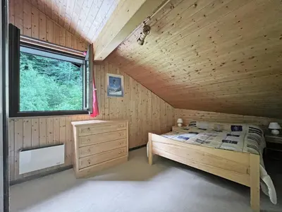 a bedroom with a bed in a wooden cabin at BA332 Appartement 4 6 Pers Pied de pistes Carroz in Les Carroz d'Araches
