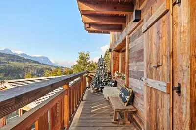 a balcony with a bench and a bunch of christmas trees at Chalet Ysalpe - Vue montagne hammam sauna jacuzzi et salle cinéma in Megève