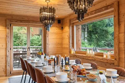 a dining room with a long table and chairs at Chalet Ysalpe - Vue montagne hammam sauna jacuzzi et salle cinéma in Megève