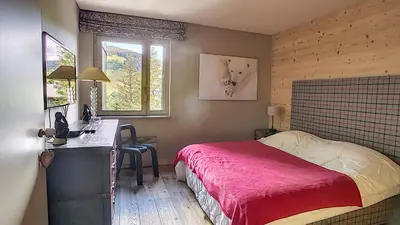 a bedroom with a bed and a desk and windows at 1 RR6169 - Rochebrune- proche pistes in Megève