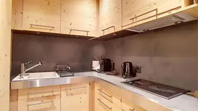 a kitchen with wooden cabinets and a sink at 1 RR6169 - Rochebrune- proche pistes in Megève