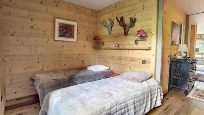 two beds in a room with wooden walls at 1 RR6169 - Rochebrune- proche pistes in Megève