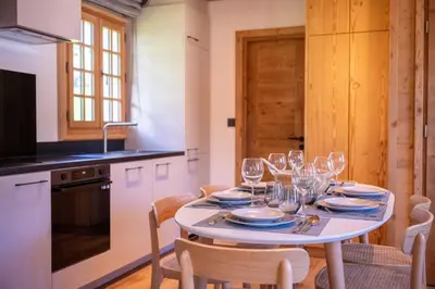 a kitchen with a table with wine glasses on it at Cozy Chalet 3BR 6P with Balcony – Megève in Megève