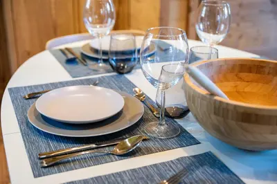 a table with plates and wine glasses on a table at Cozy Chalet 3BR 6P with Balcony – Megève in Megève