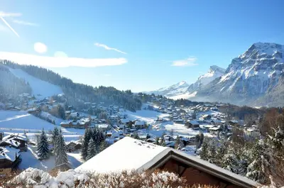 a village covered in snow with a mountain in the background at MAR219 - Appartement 4 5 pers centre village in Les Carroz d'Araches