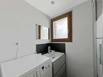 a white bathroom with a sink and a window at MAR219 - Appartement 4 5 pers centre village in Les Carroz d'Araches