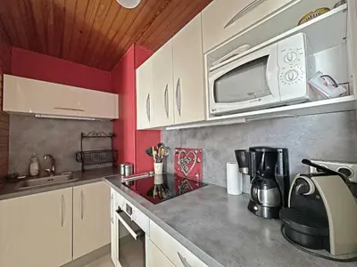 a kitchen with white cabinets and a microwave at MAR219 - Appartement 4 5 pers centre village in Les Carroz d'Araches