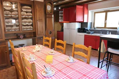 a kitchen with a table with a red and white checkered table cloth at La Ferme De Réjane in Saint-Gervais-les-Bains