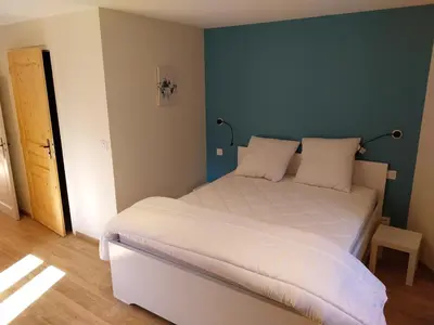 a bedroom with a white bed with a green wall at La Ferme De Réjane in Saint-Gervais-les-Bains