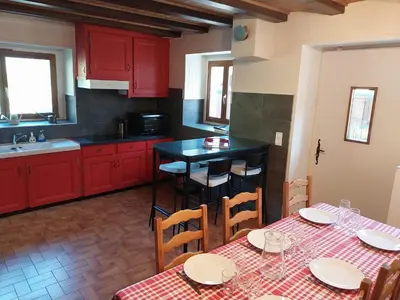 a kitchen with red cabinets and a table and chairs at La Ferme De Réjane in Saint-Gervais-les-Bains