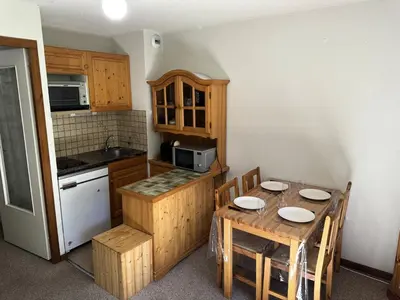 a kitchen with a wooden table and a table and chairs at Résidence Ecrin Des Glacier Aiglon - Ecrin des glaciers Aiglon 14 MAE-2783 in Combloux