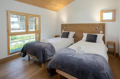 two beds in a room with a window at Chalet Couttet - Chamonix All Year in Chamonix-Mont-Blanc