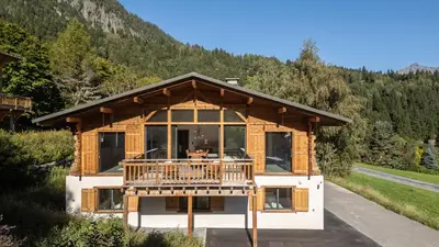 a log home with a deck in the snow at Chalet Monski in Les Houches