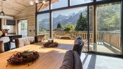 a dining room with a table and a large window at Chalet Monski in Les Houches