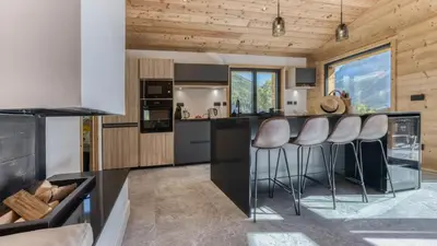 a kitchen with a bar with stools in it at Chalet Monski in Les Houches