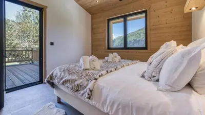 a bedroom with a large bed with white pillows at Chalet Monski in Les Houches