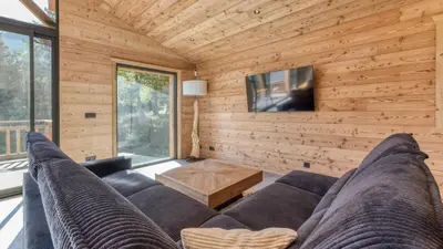 a living room with a couch and a tv at Chalet Monski in Les Houches