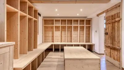 a dressing room with wooden shelves and a bench at Chalet Deutz in Chamonix-Mont-Blanc