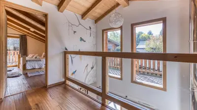 an empty living room with wooden ceilings and windows at Chalet Deutz in Chamonix-Mont-Blanc