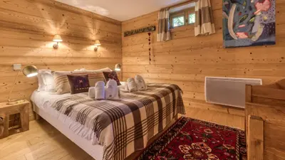 a bedroom with a bed in a room with wooden walls at Chalet Mowgli in Chamonix-Mont-Blanc