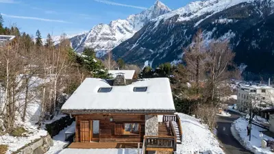 a log home with a wrap around porch and a wrap around deck at Chalet Mowgli in Chamonix-Mont-Blanc