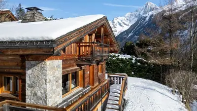 a log home with a large deck and mountains at Chalet Mowgli in Chamonix-Mont-Blanc
