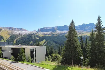 a building on the side of a road with trees at Joli T2 Flaine Foret, oriente sud, linge & menage compris in Flaine