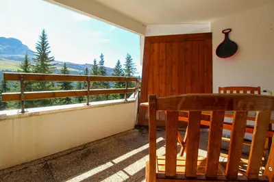 a wooden bench sitting on a balcony with a view at Joli T2 Flaine Foret, oriente sud, linge & menage compris in Flaine