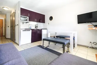 a living room with a table and a kitchen at Joli T2 Flaine Foret, oriente sud, linge & menage compris in Flaine