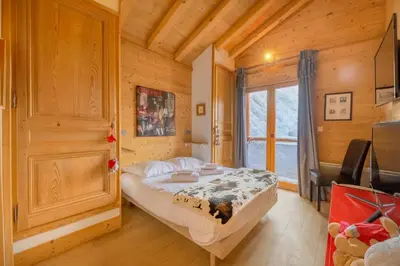 a bedroom with a bed in a wooden house at Luxury Chalet Pool & Jacuzzi near Megeve in Sallanches