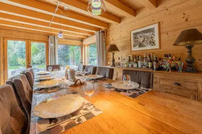 a dining room with a long table with wine glasses at Luxury Chalet Pool & Jacuzzi near Megeve in Sallanches