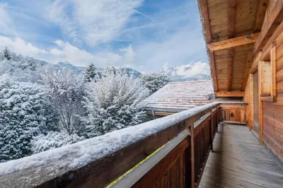a balcony of a cabin with snow covered trees at Luxury Chalet Pool & Jacuzzi near Megeve in Sallanches