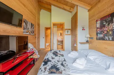 a bedroom with a bed and a flat screen tv at Luxury Chalet Pool & Jacuzzi near Megeve in Sallanches