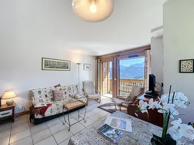 a living room with a couch and a balcony at Appartement 2 chambres, vue Mont Blanc, parking inclus - FR-1-560-168 in Combloux
