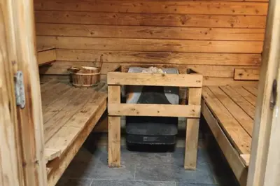 a small room with a stove in a wooden cabin at Cozy apartment with pool and golf nearby in Megève