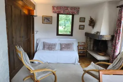 a bedroom with a bed and two chairs and a fireplace at Cozy apartment with pool and golf nearby in Megève