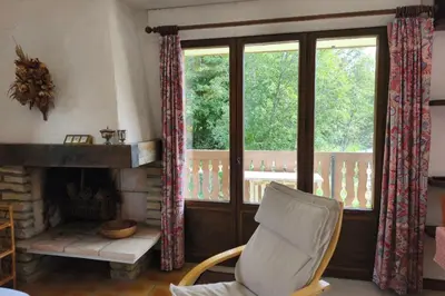 a living room with a chair and a fireplace at Cozy apartment with pool and golf nearby in Megève