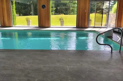 a swimming pool with a bench in a house at Cozy apartment with pool and golf nearby in Megève