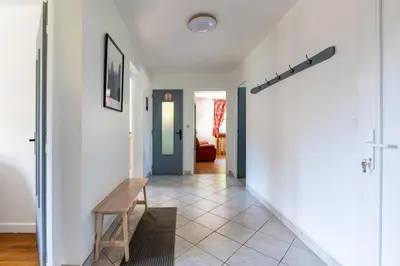 a hallway with white walls and a wooden bench at Grand Appartement-Vue Montagne-Wi-Fi-Parking in Magland