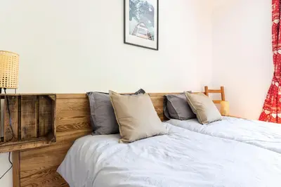 two beds sitting next to each other in a bedroom at Grand Appartement-Vue Montagne-Wi-Fi-Parking in Magland